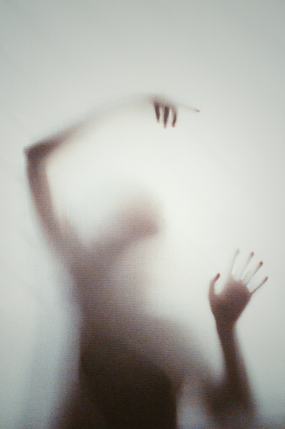 A woman seen through gauze, with various parts of her body visible and invisible
