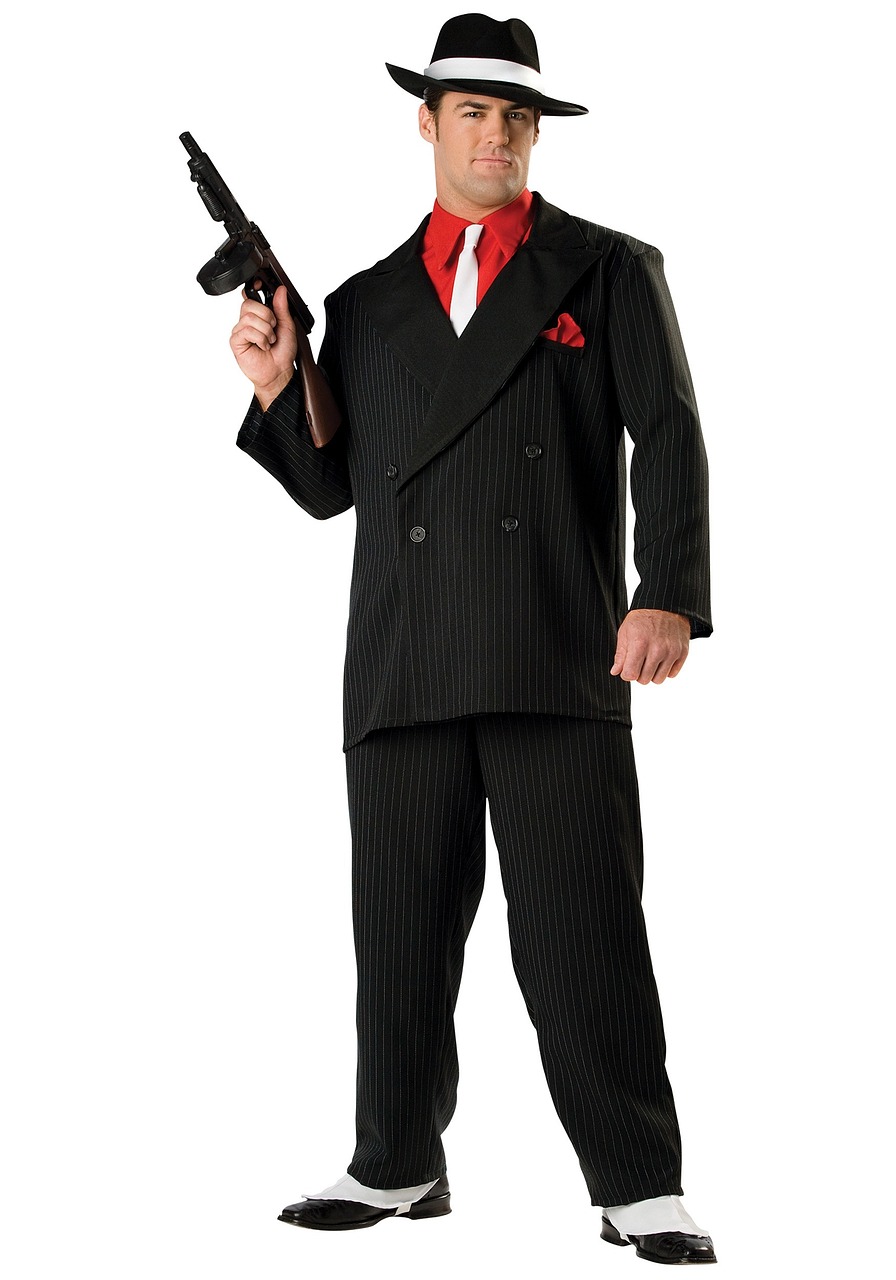 A man in a gangster's zoot suit, complete with fedora and tommy-gun