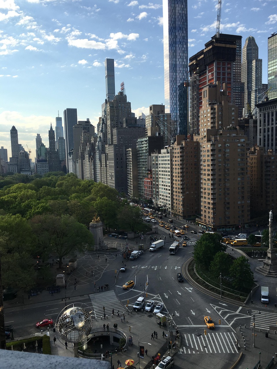 A view of the edge of Central Park, New York, with traffic, skyscrapers, and trees