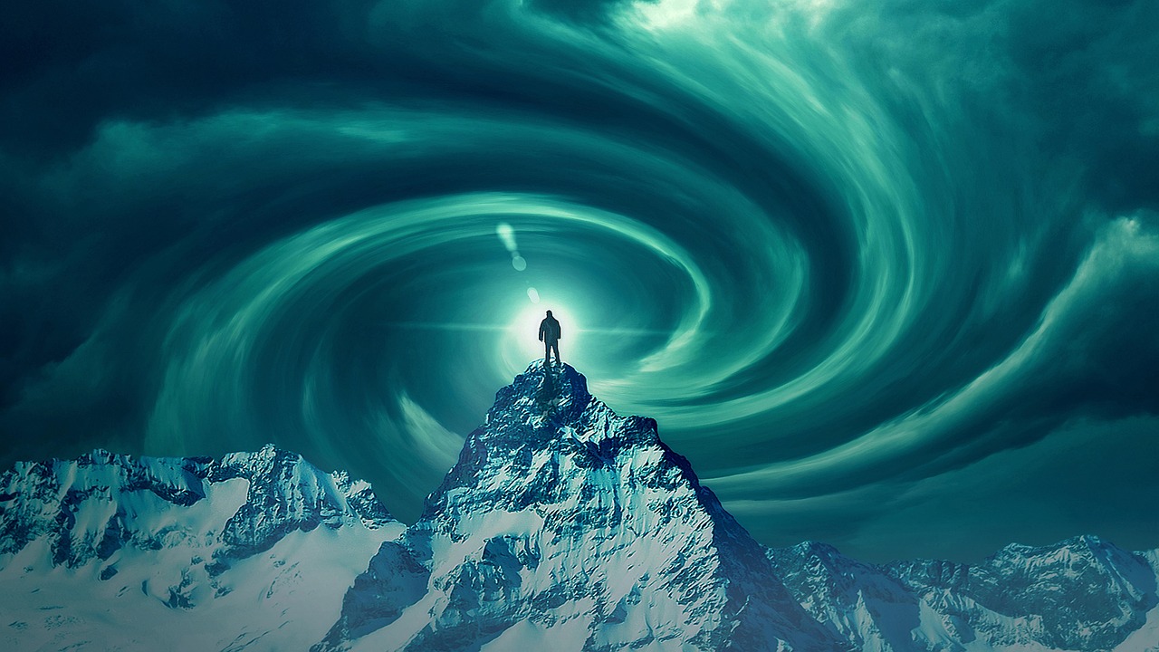 A man at the apex of a mountain, silhouetted against a glowing sky that is swirling into a cosmic portal